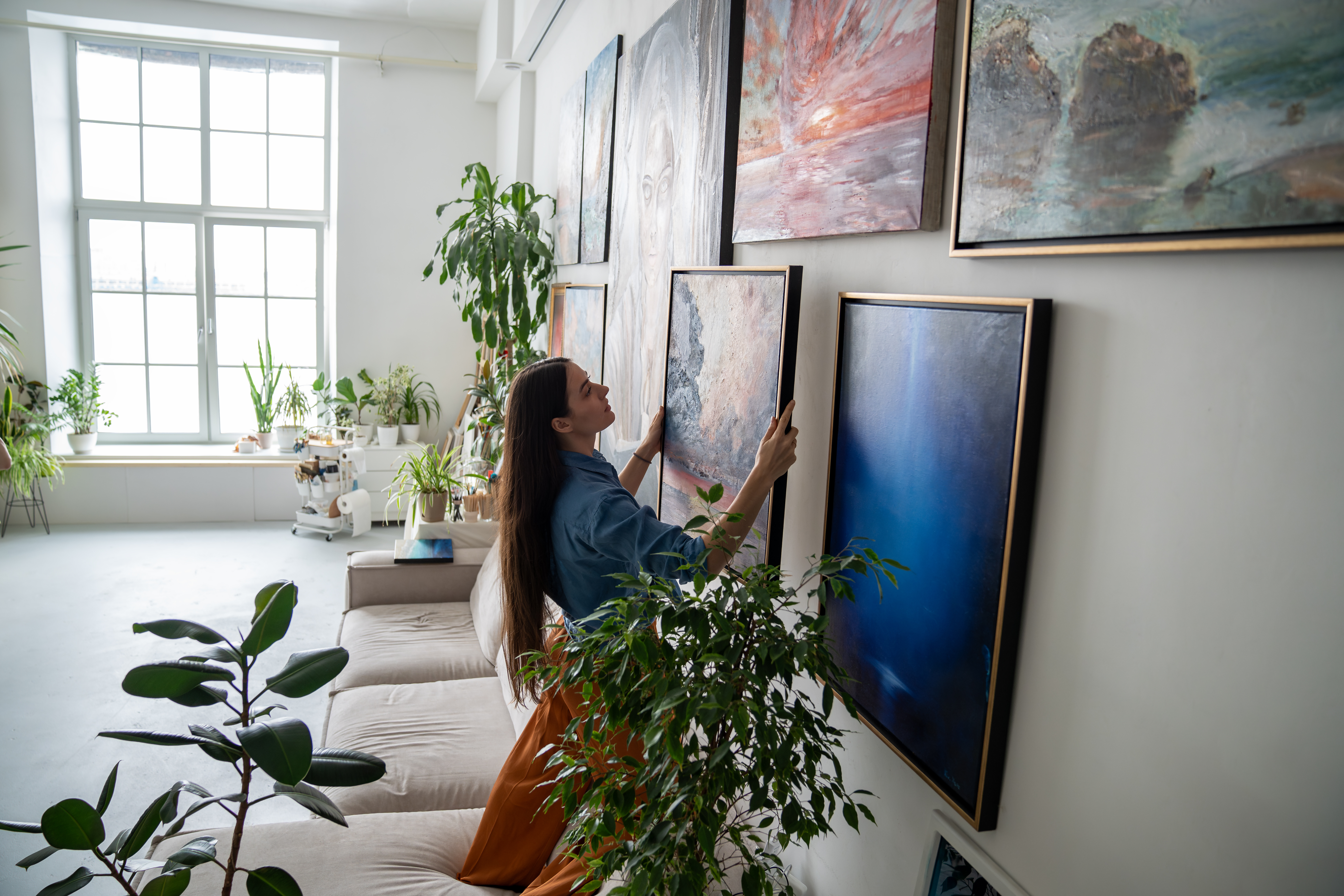 woman making gallery wall in home