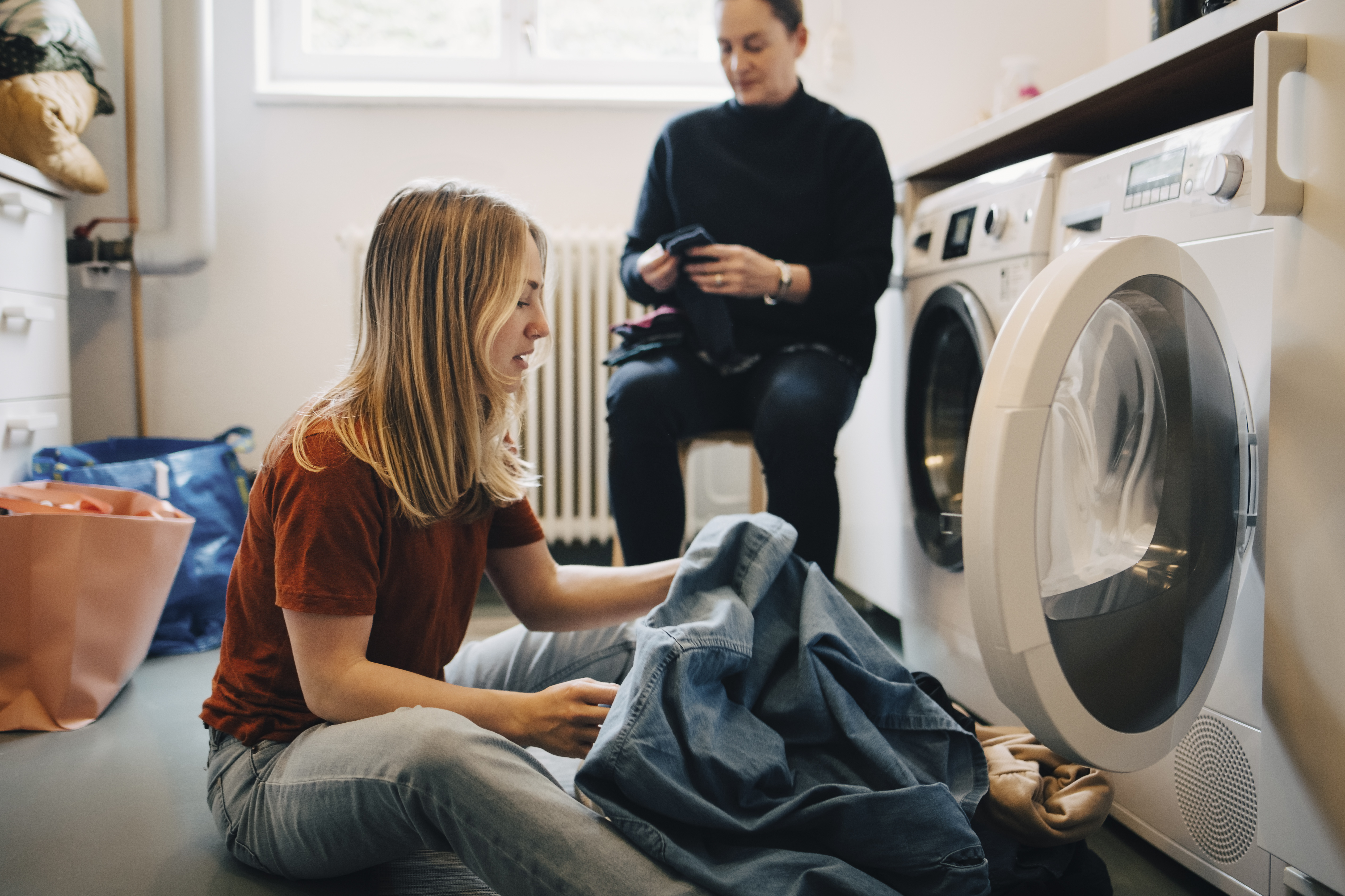 Woman putting clothes in washing machine