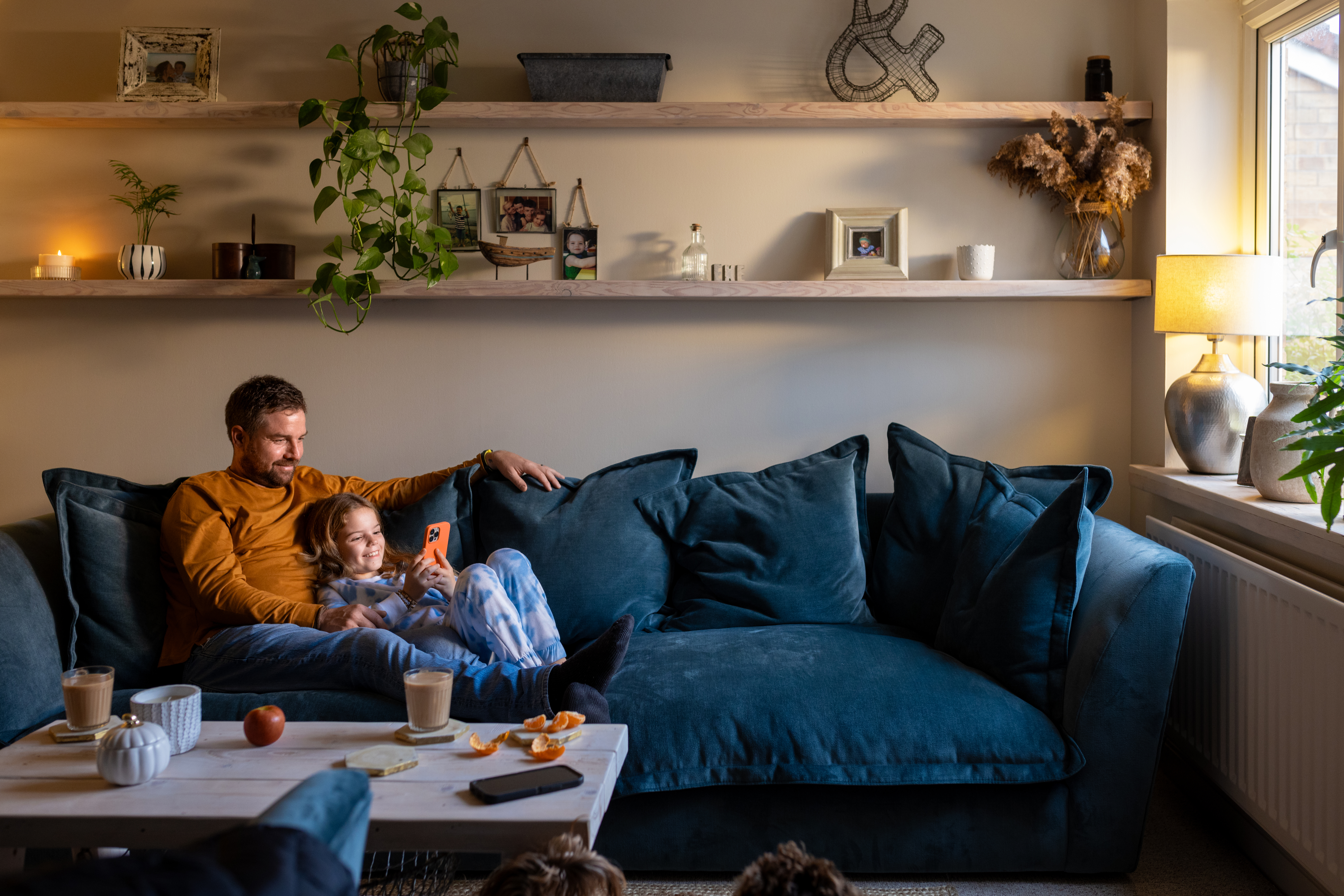 Father lying down on the sofa with his daughter