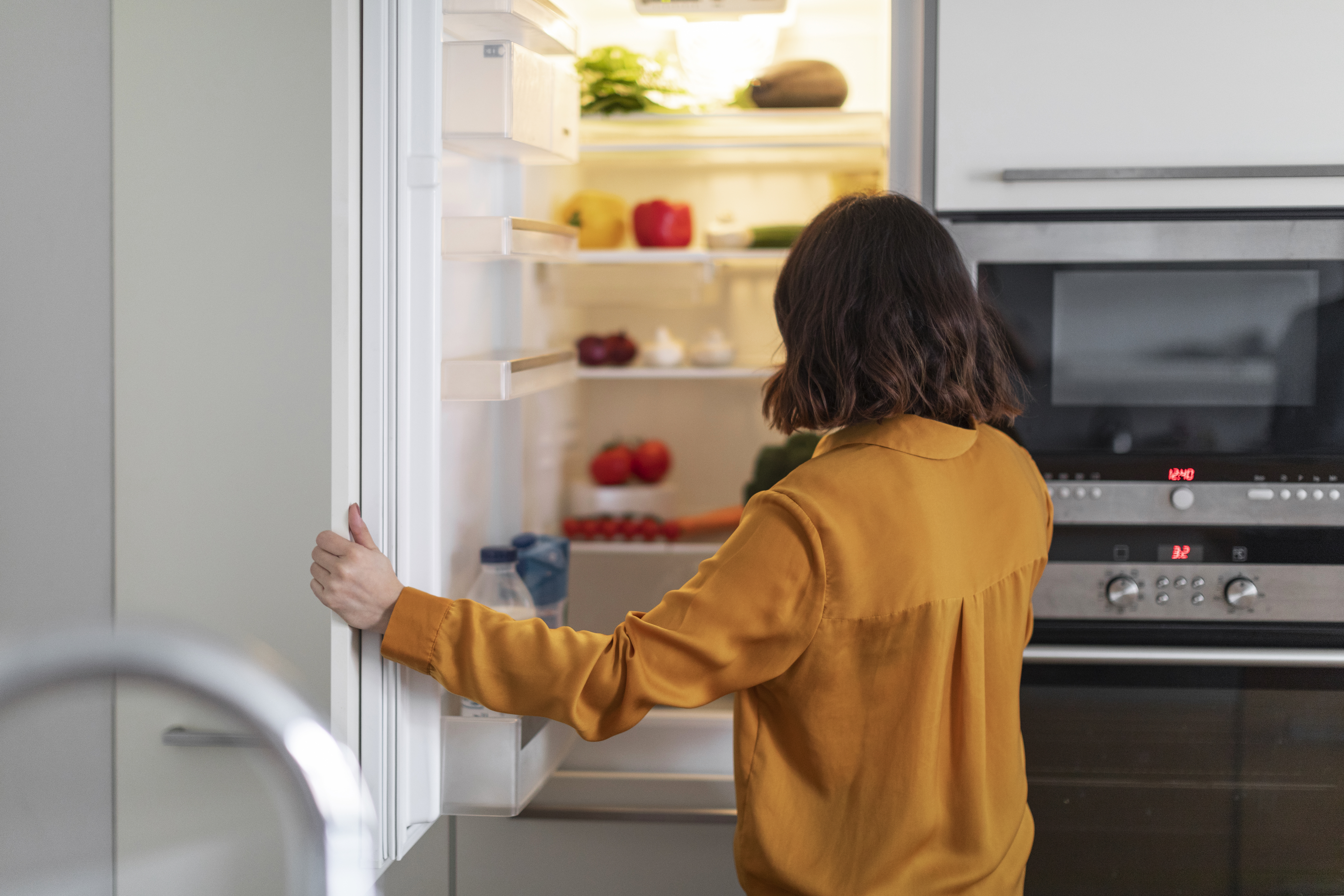 A person opening a refrigerator