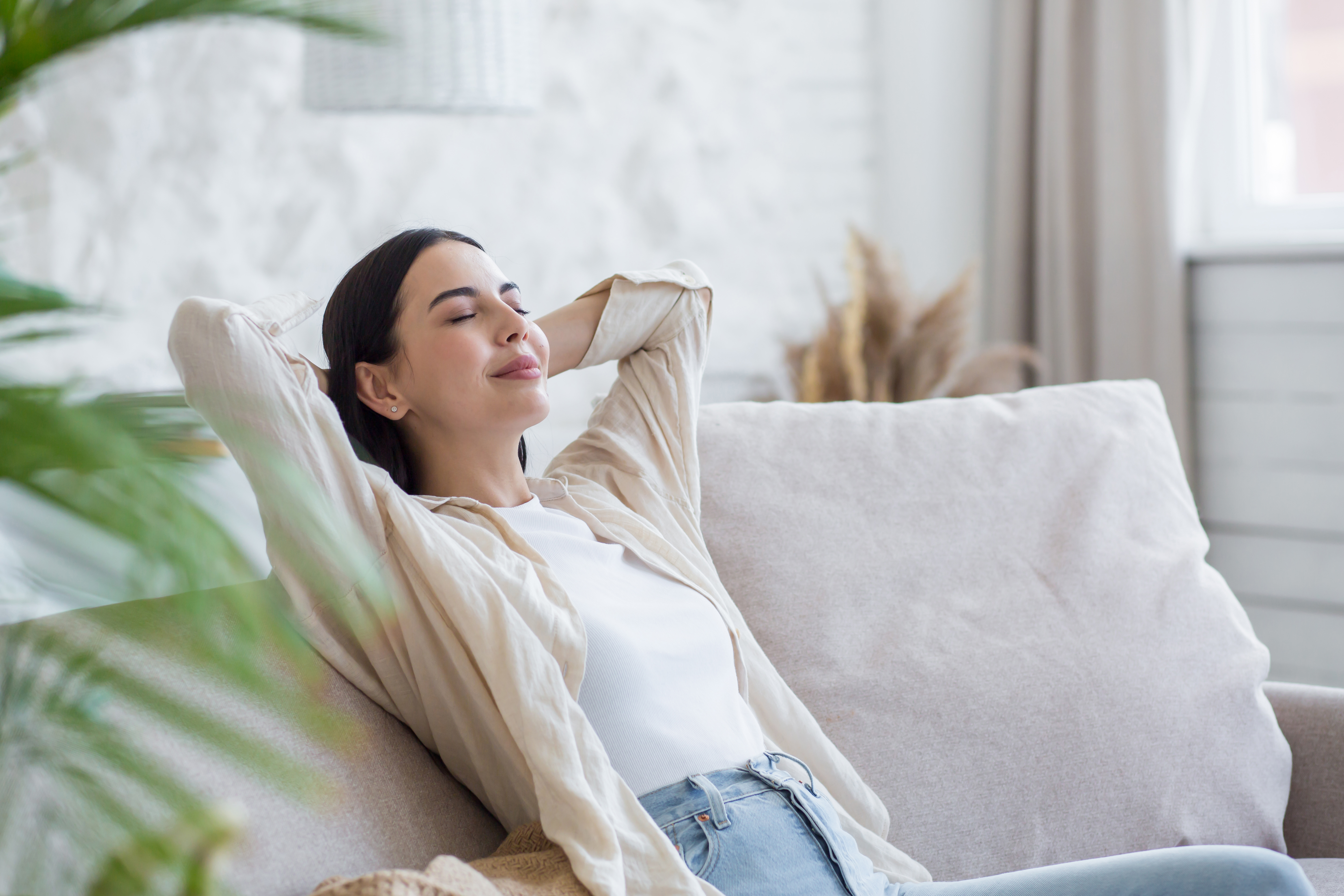 A woman with eyes closed is relaxing at home 