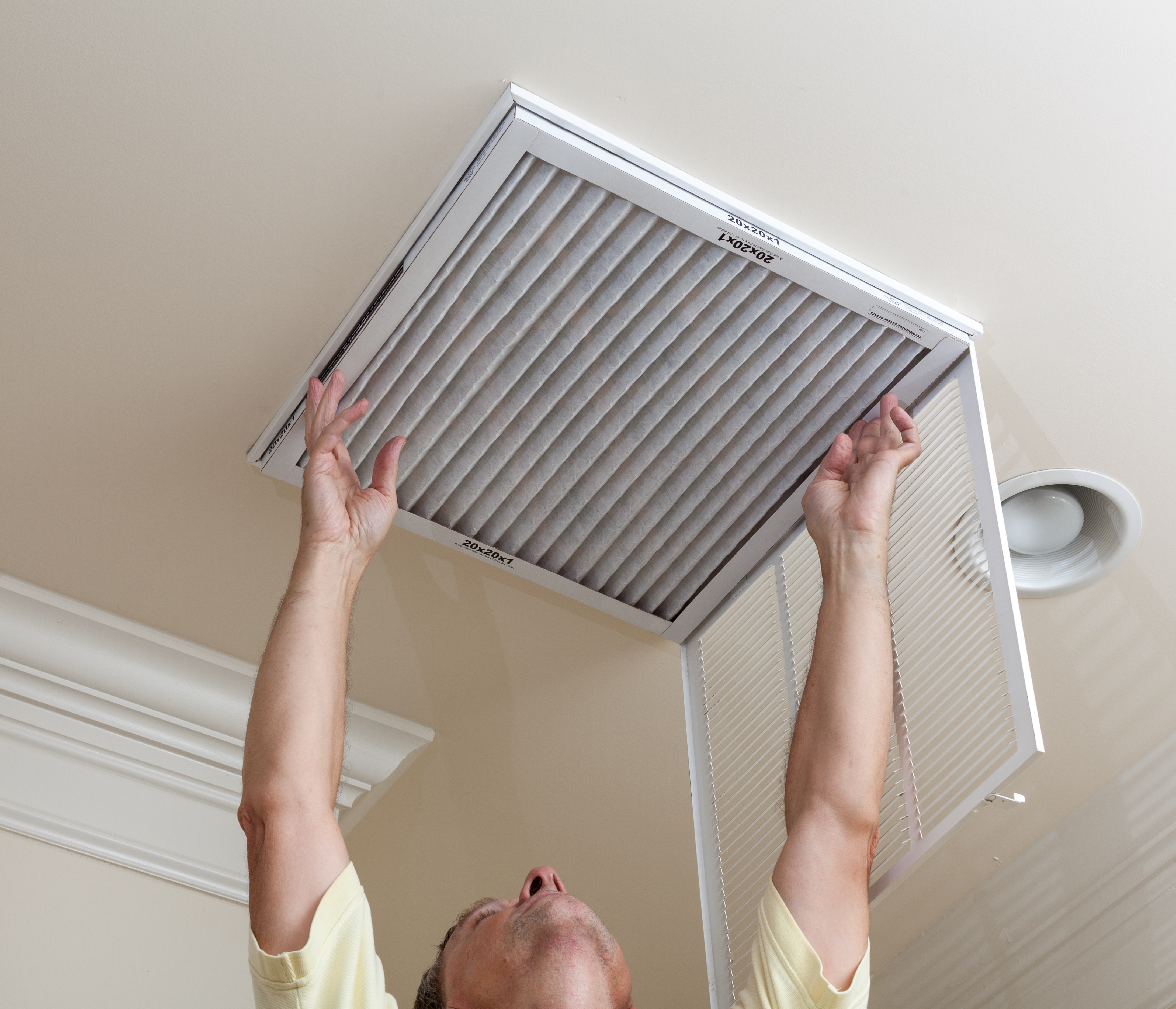Handyperson installing a new HVAC air filter at home 
