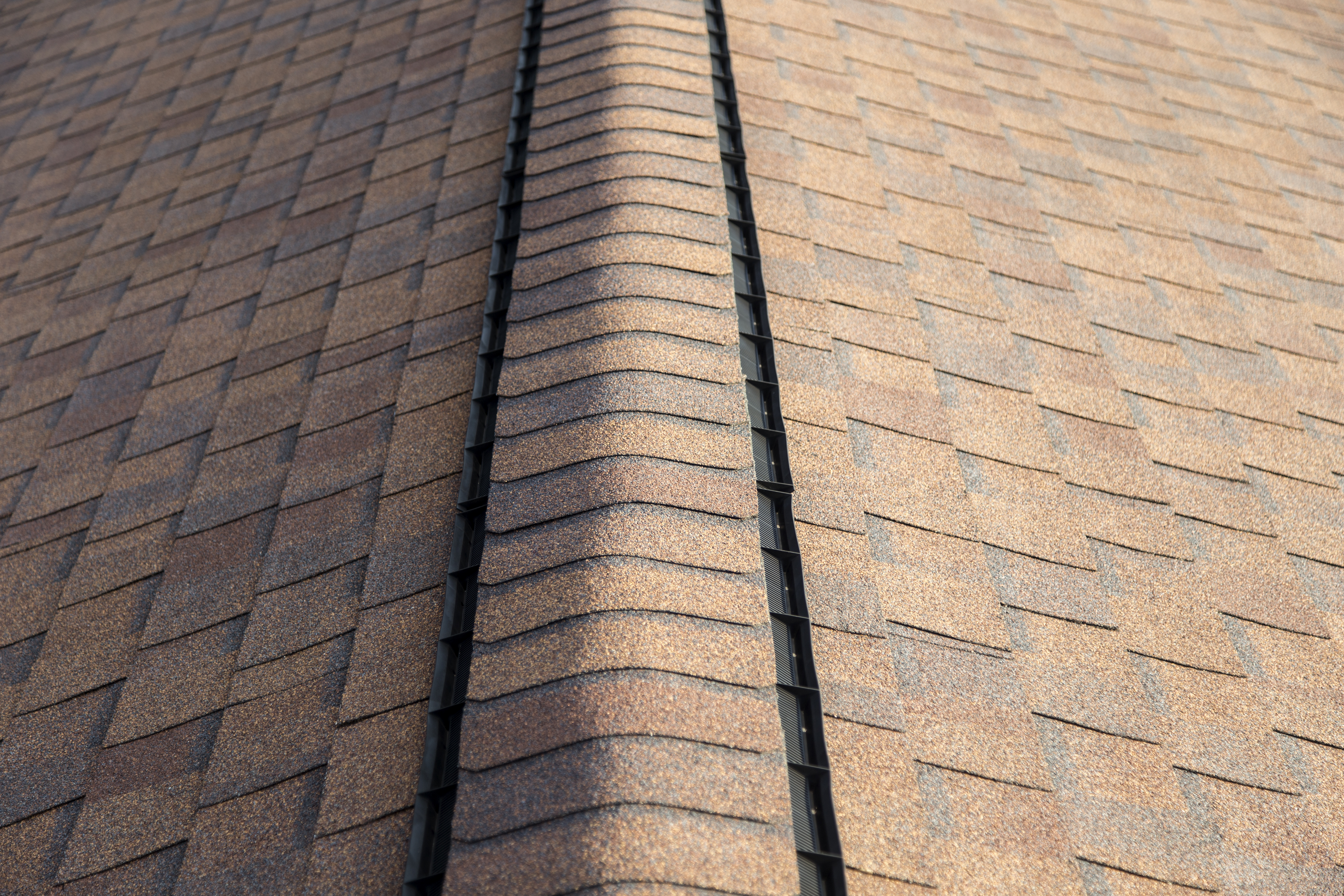 A roof ridge vent with cap on top of it