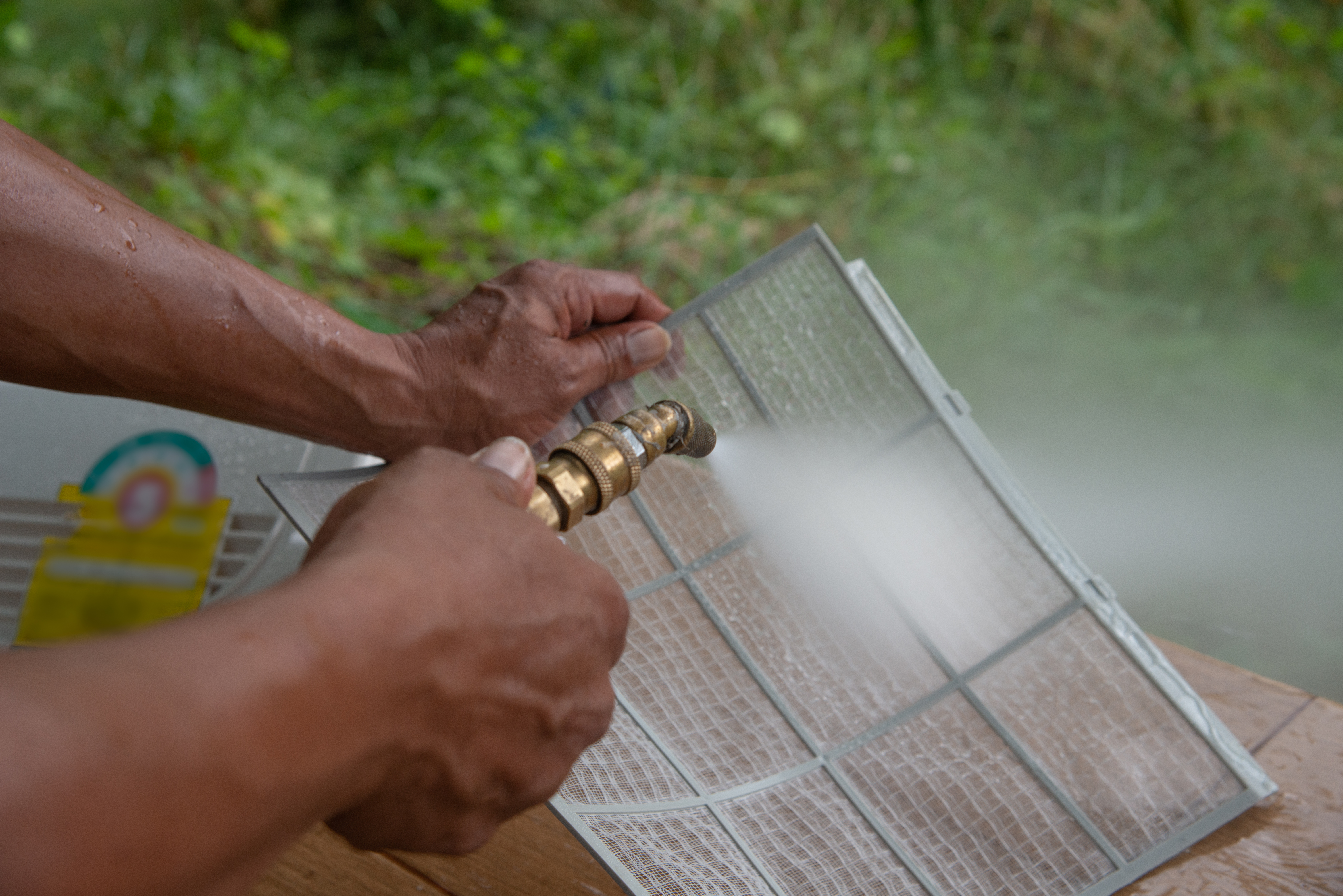 man cleaning mini split filter