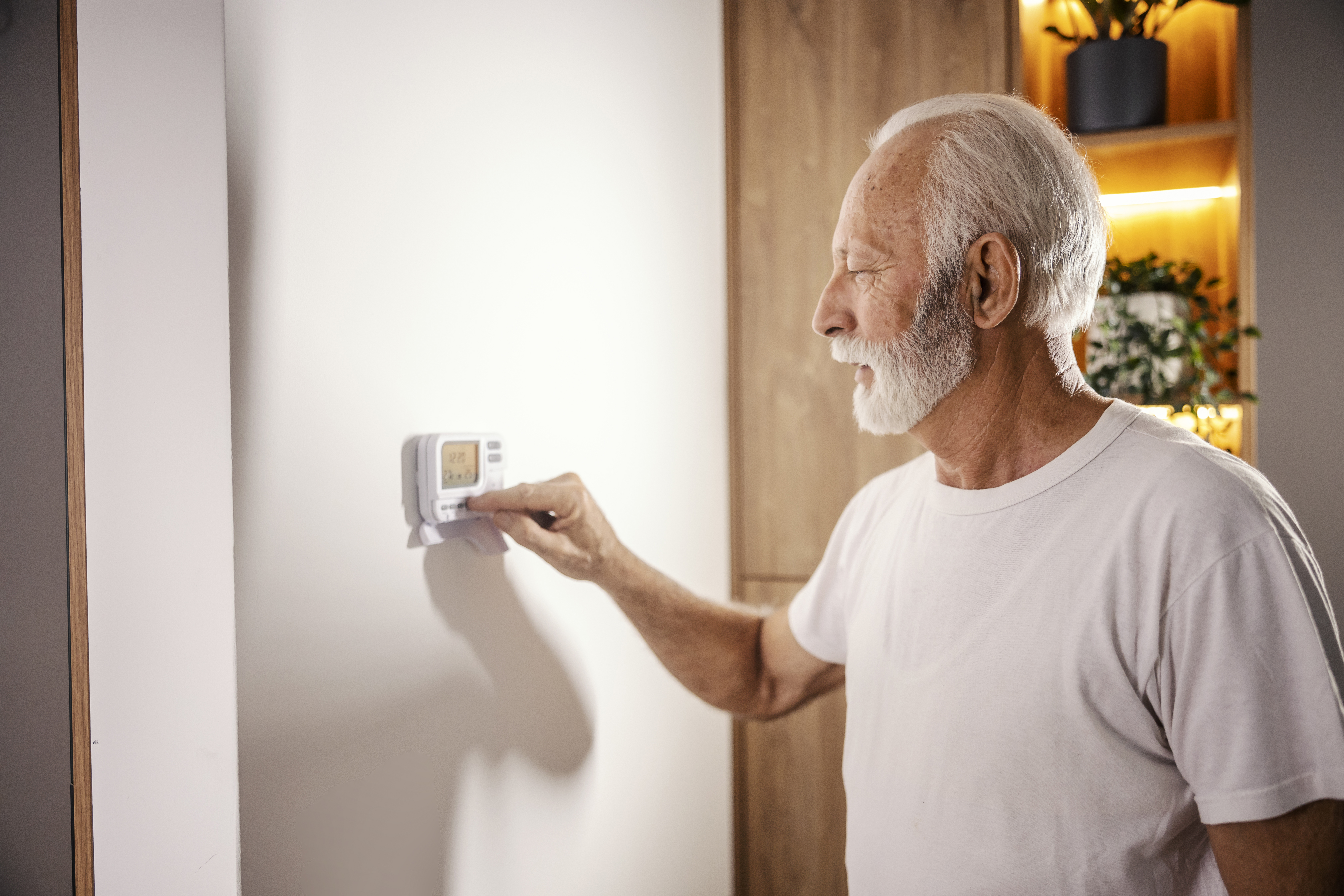 The man is adjusting the central heating 