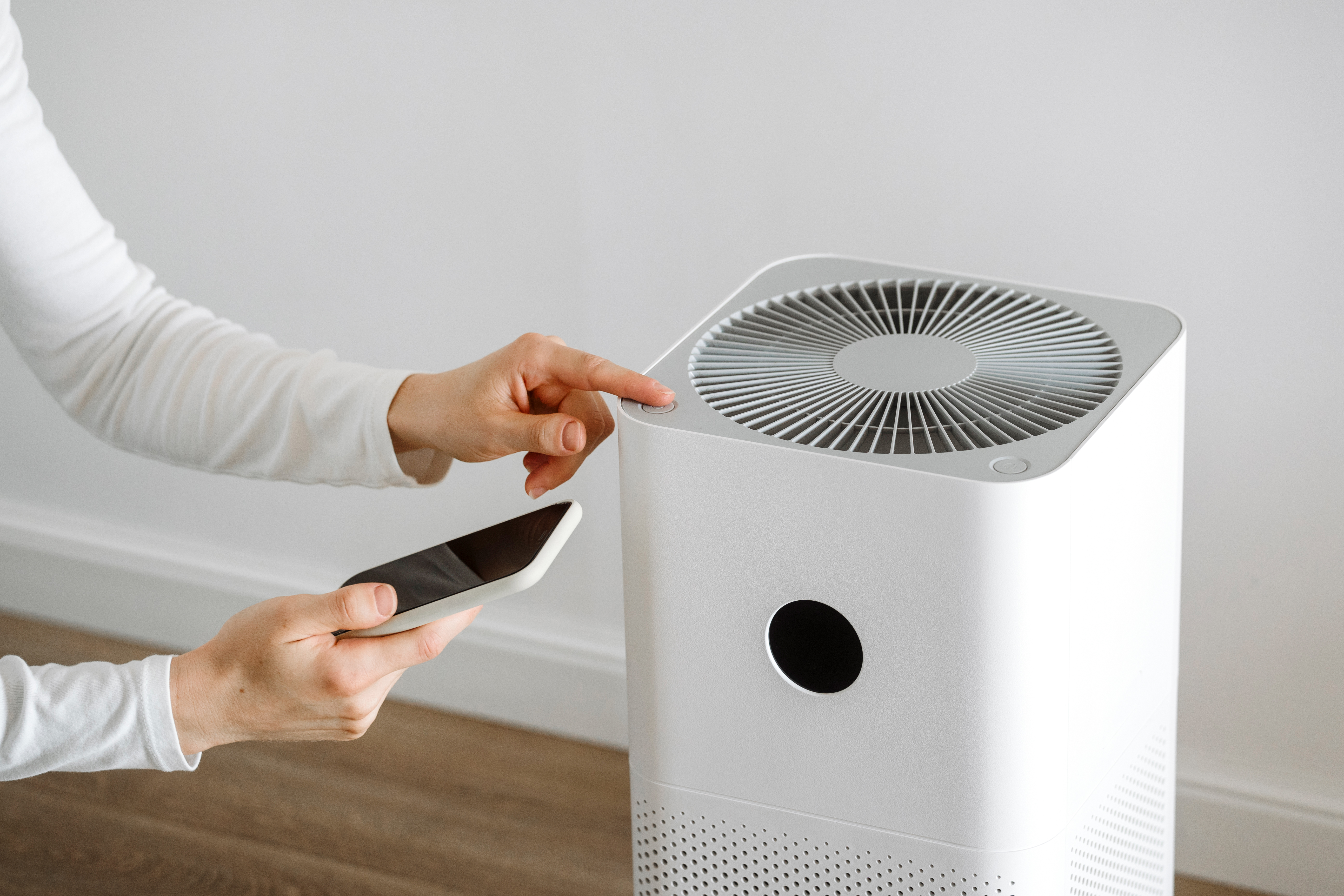 Woman holding a smartphone with an air purifier application
