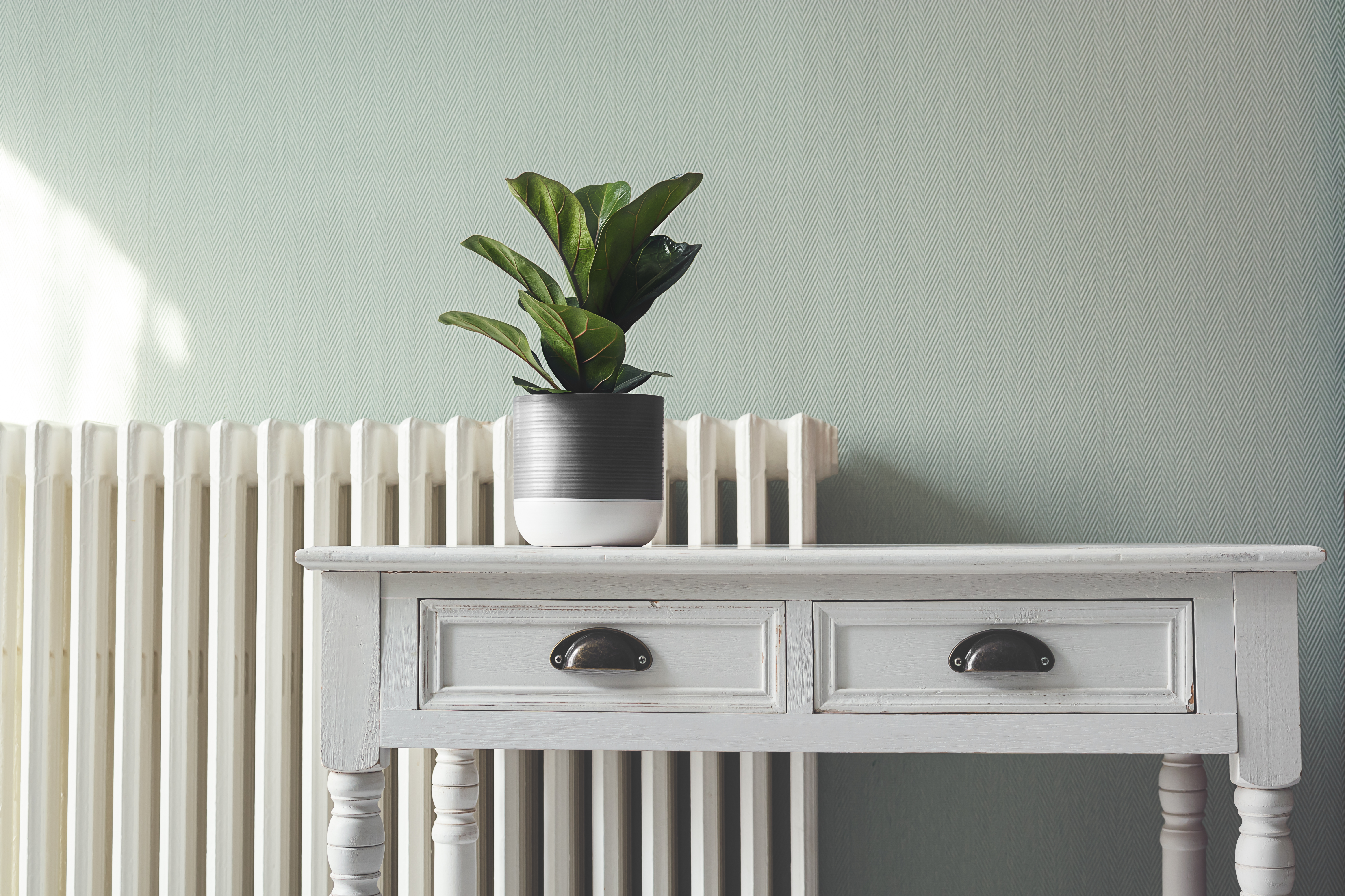 A white vintage dresser in front of a radiator 