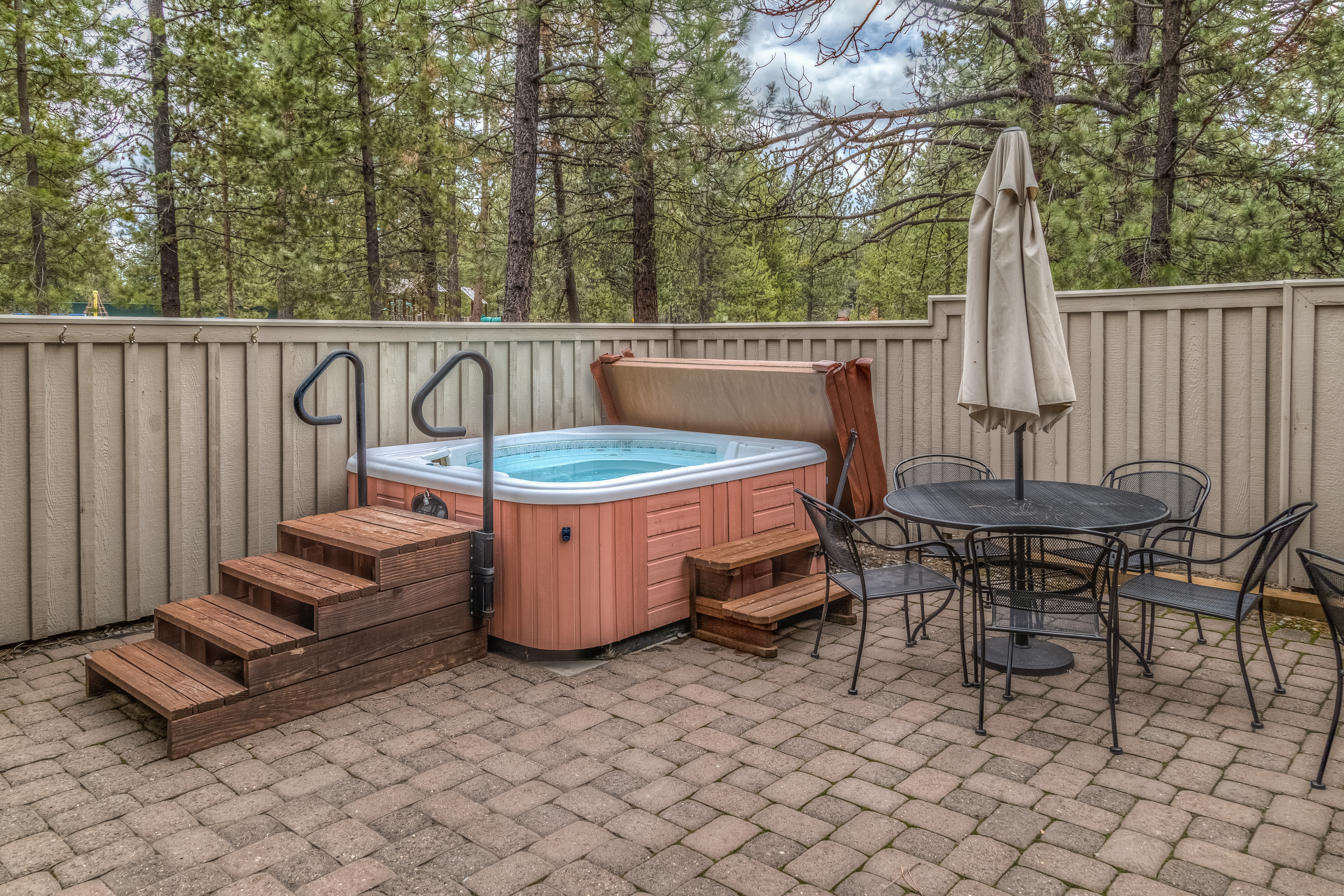 Hot tub with wooden steps on a house patio