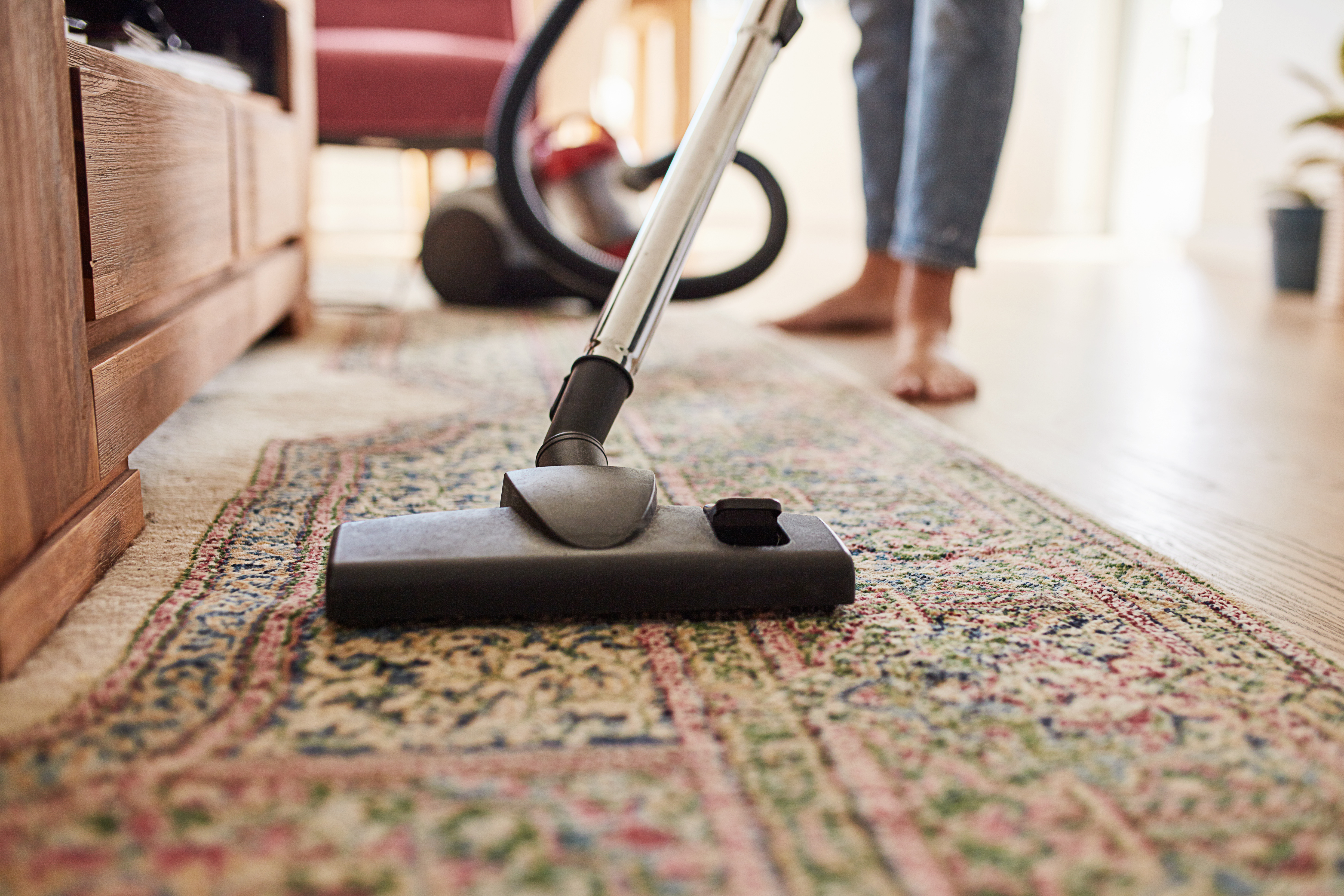A person vacuuming a rug