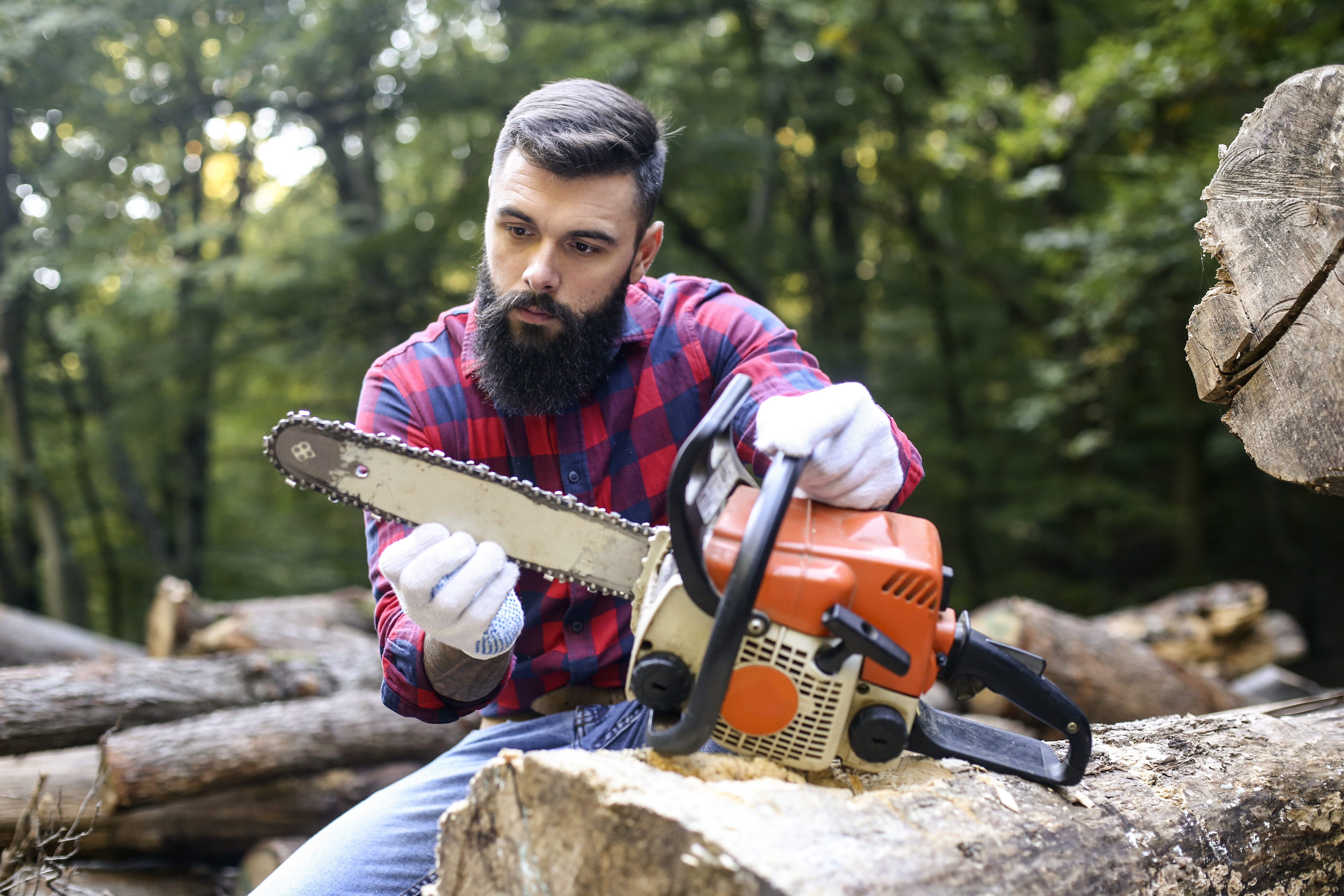 A man inspecting a chainsaw