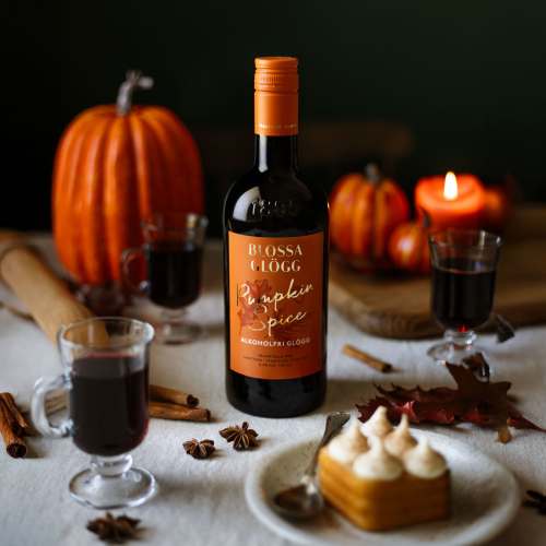 Blossa Pumpkin Spice på bord med pumpor och morotskaka.