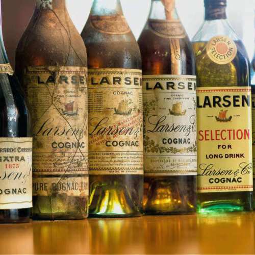 Samling av gamla flaskor Larsen Cognac