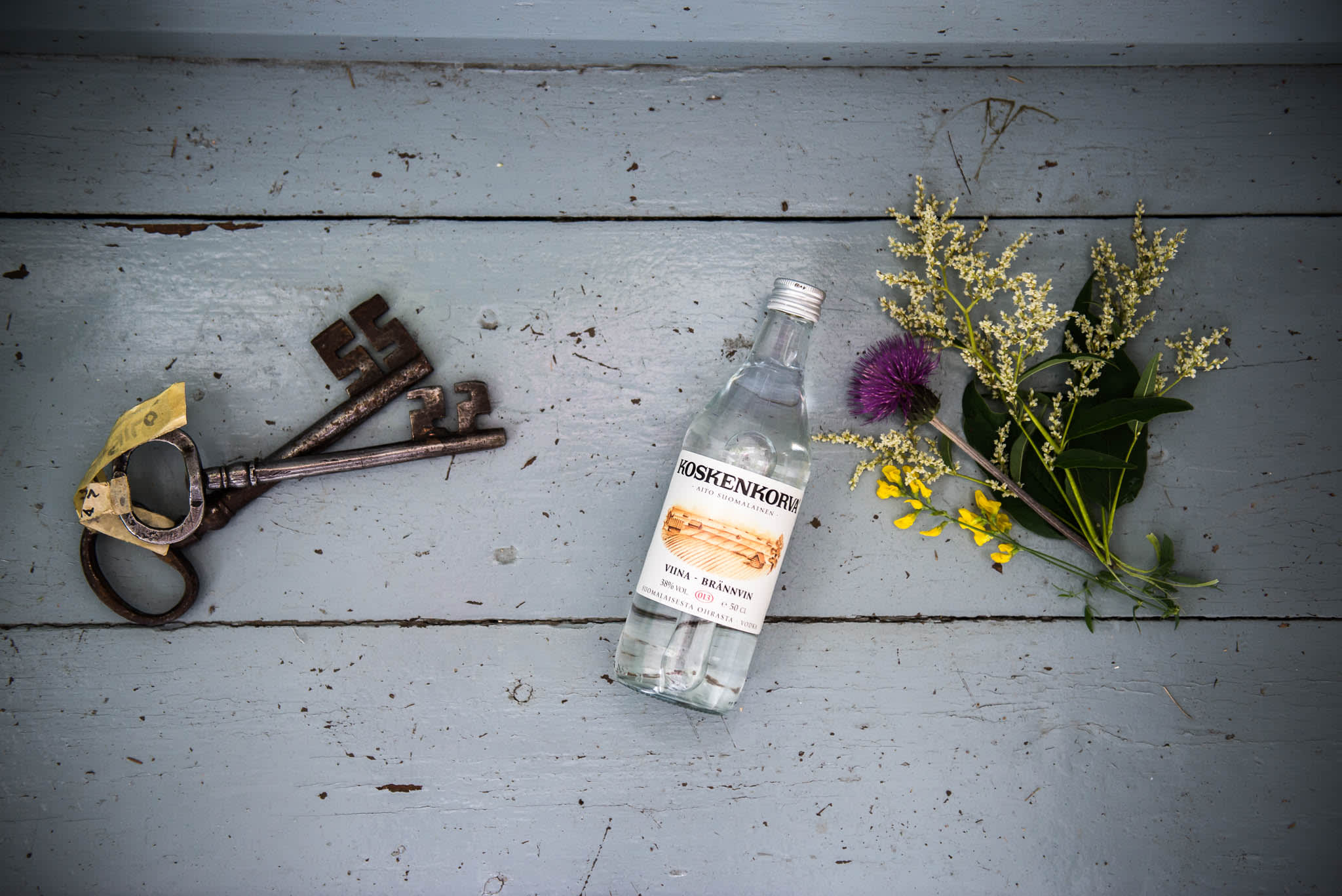 Koskenkorva bottle, old keys and punch of flowers