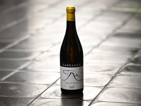 En flaska Etna Bianco på grå stenplattor.