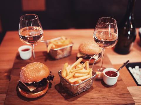 Hamburgare med pommes och två glas vitt vin.