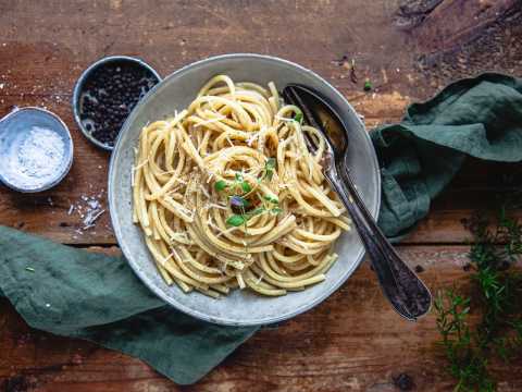 Cacio e pepe i en tallrik dukat på ett bord 