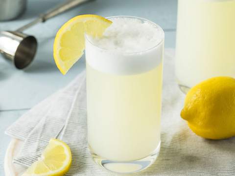 Cocktailglas med gin fizz på bord