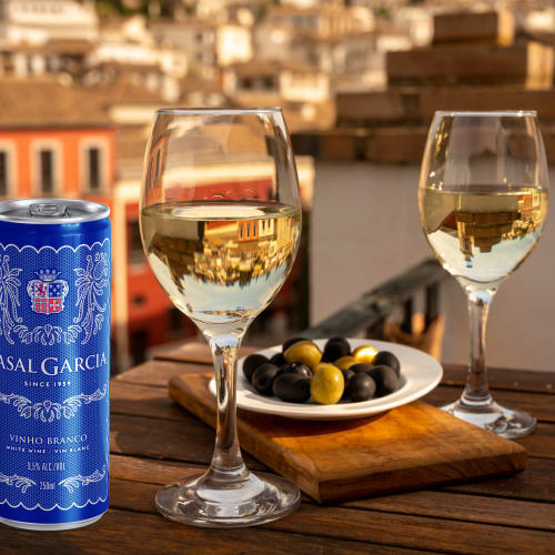 Vinburk och två vinglas samt fat med oliver med utsikt över portugisist stad.