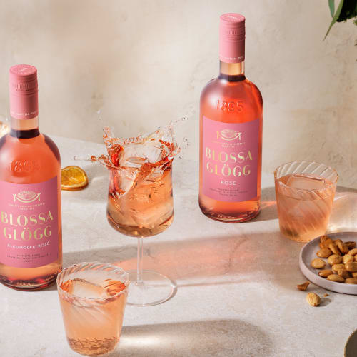 Blossa Rosé - med 10% alkohol samt alkoholfri på ett bord med glas.