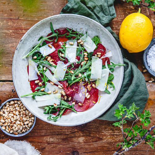 Sallad med bresaola, pinjenötter och citron på fat