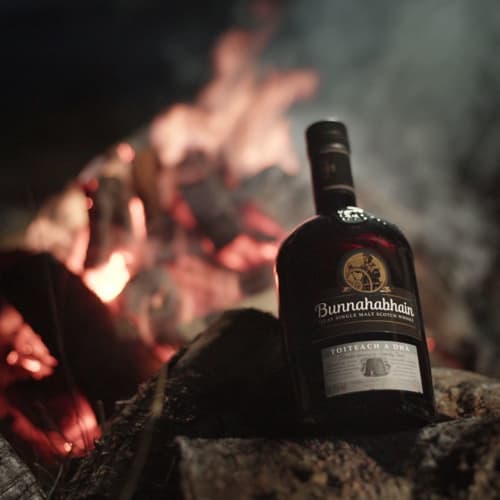  Bunnahabhain Toiteach A Dhà med brasa i bakgrunden