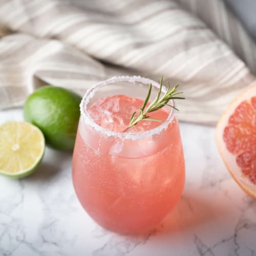 Paloma med en halv grapefrukt och lime på marmorbord