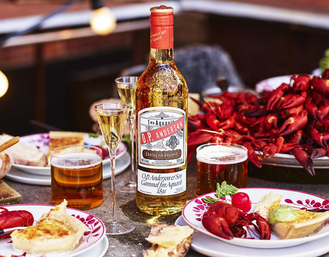 O.P. Anderson Aquavit på ett bord uppdukat med kräftor och alla tillbehör till kräftskivan.