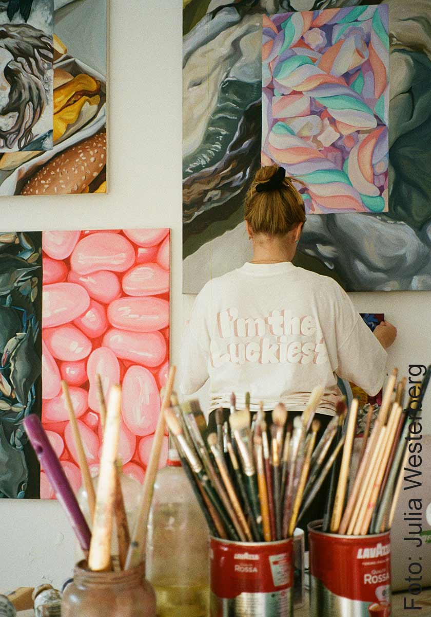 Malin Molin med målningar från utställningen Magen