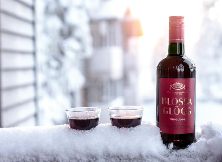 Two Blossa Vin Glögg glasses and bottle in snow