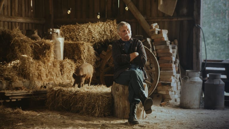 Koskenkorva villager sitting on a haystack