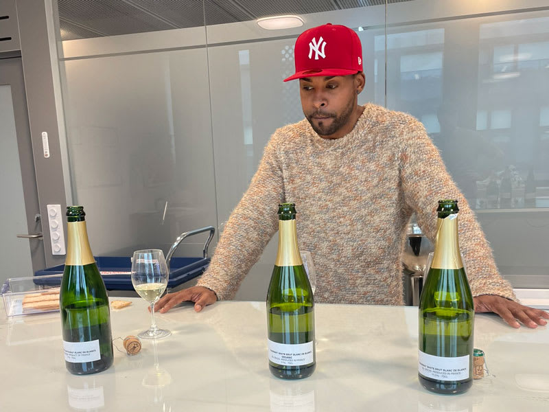 John Lundvik med tre vinflaskor på ett bord.