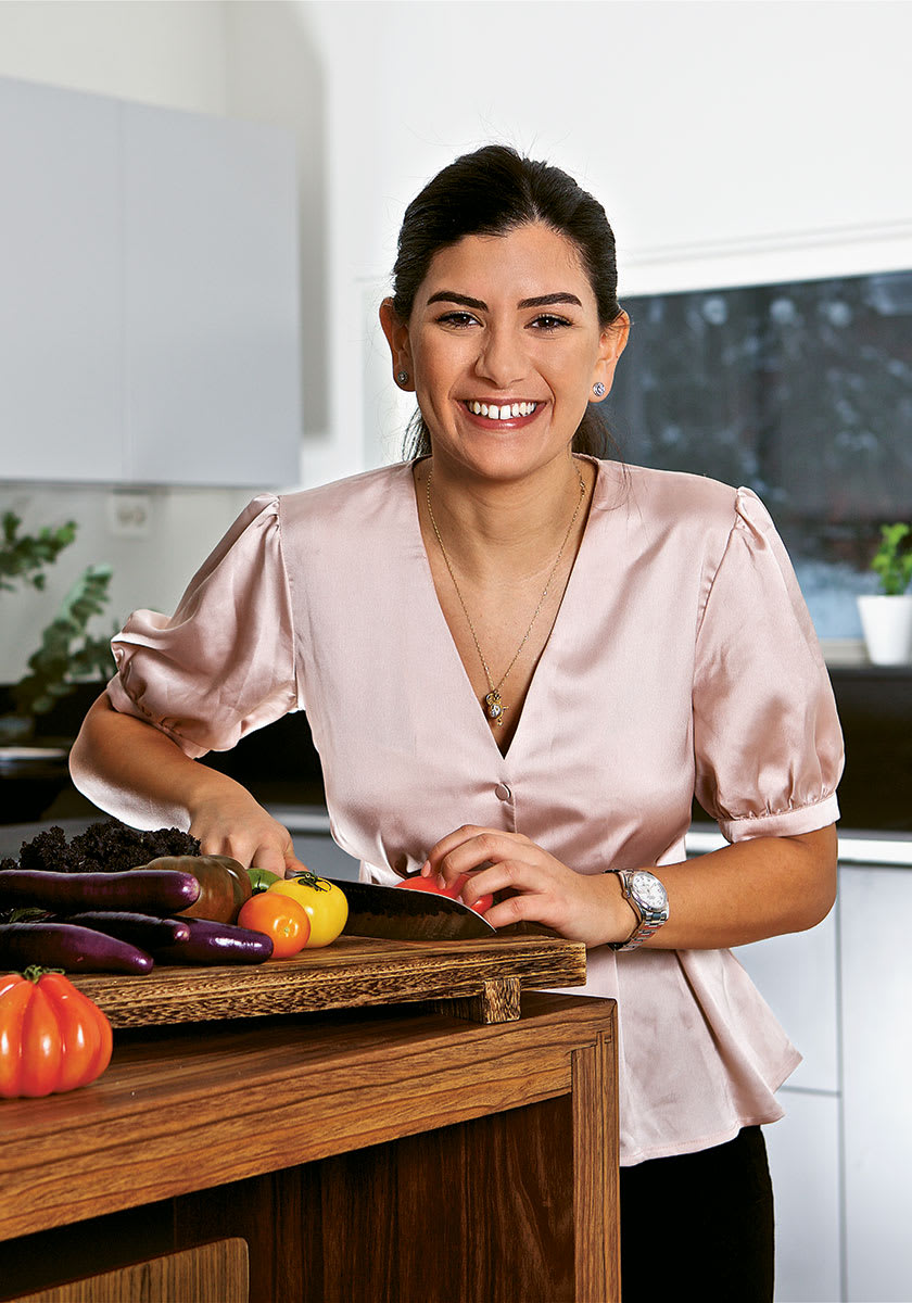 Kristin Kashou vid skärbräda med grönsaker