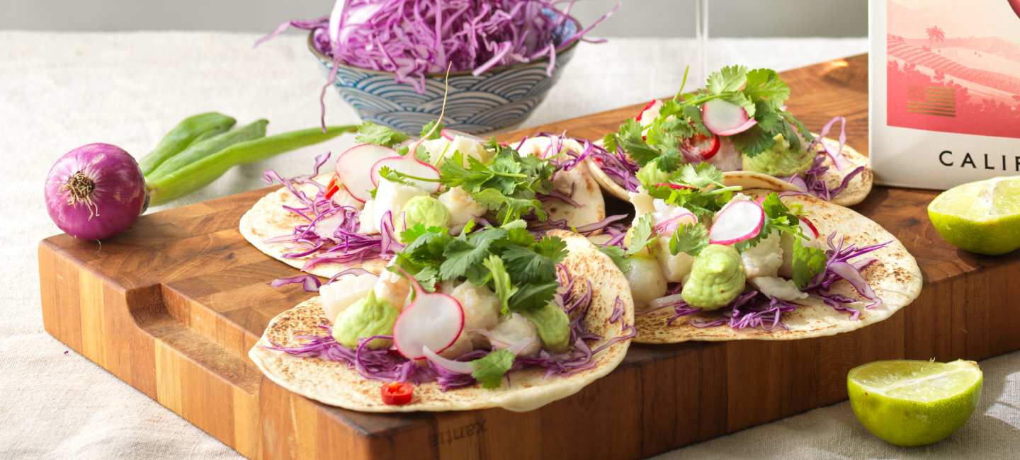 Fish taco med avokadokräm och tillbehör.