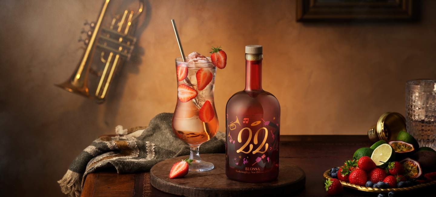 Blossa 22 Hurricane Spritz - en drink med flaskan på ett träbord.