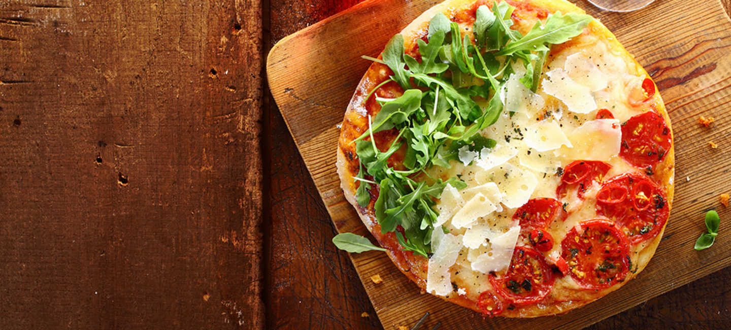 Pizza med ruccola, parmesan och tomat