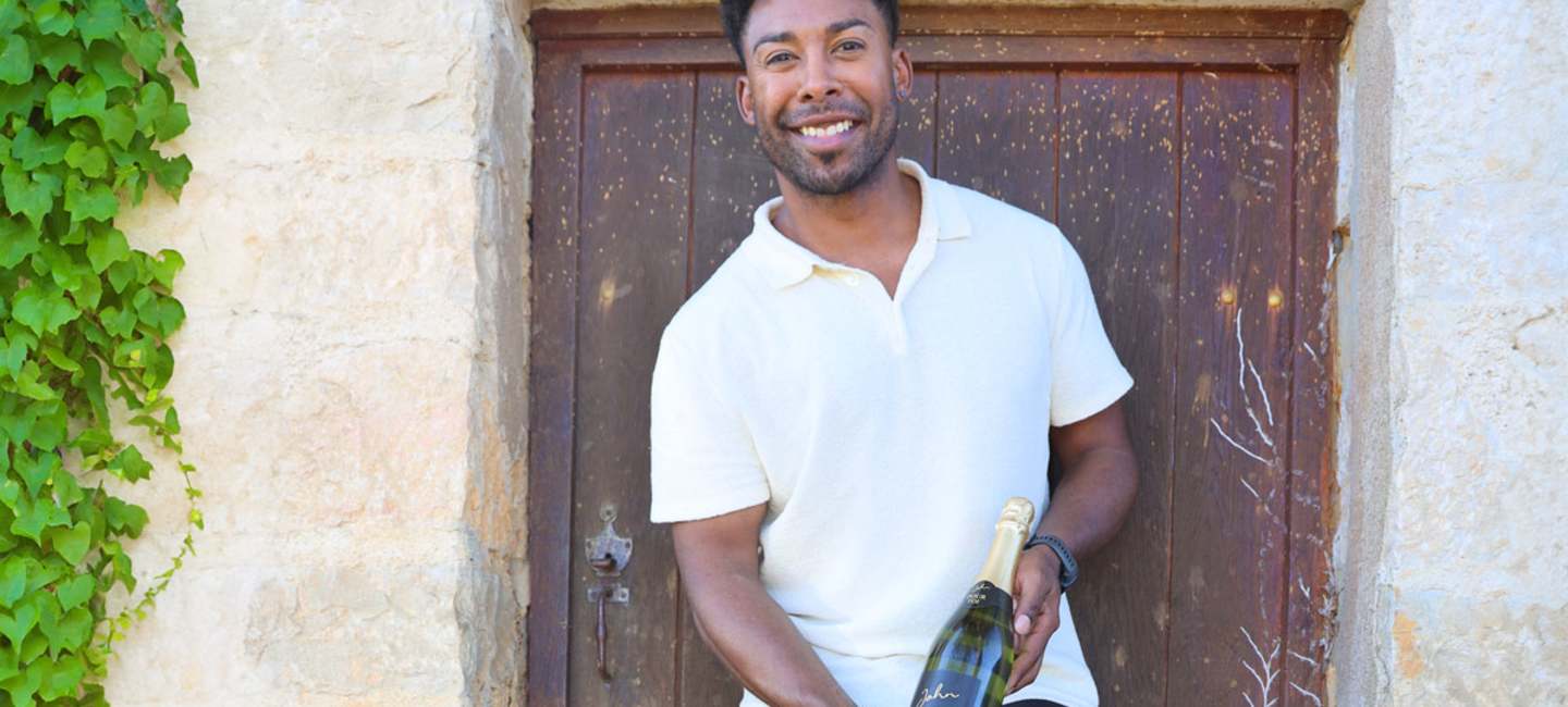 John Lundvik mot en brun dörr till ett stenhus i Bourgogne.