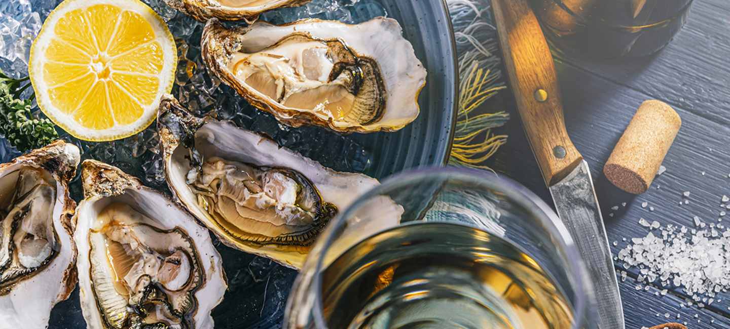 Ostron på fat och ett glas vin