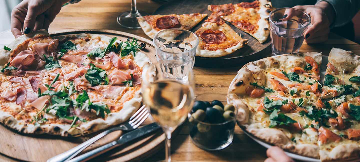 Pizza och vinglas på bord