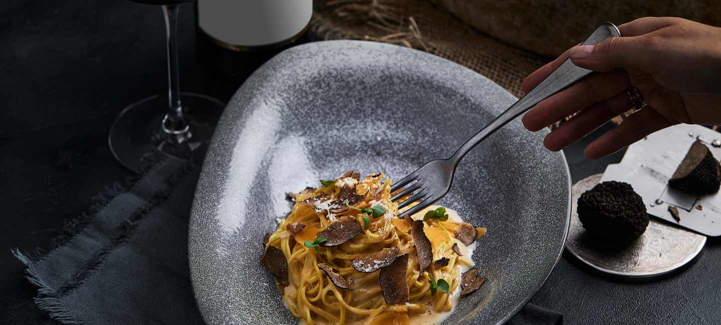 Tallrik med pasta med hyvlad tryffel på.