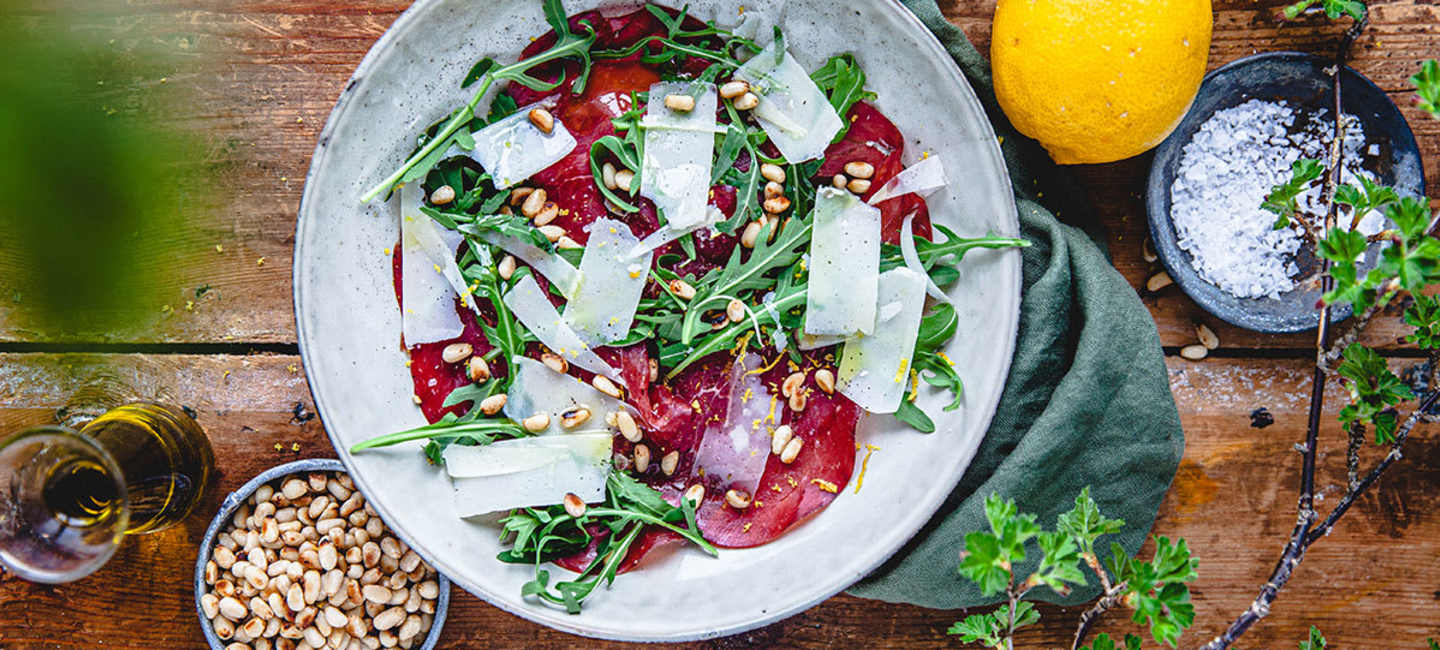 Sallad med bresaola, pinjenötter och citron på fat