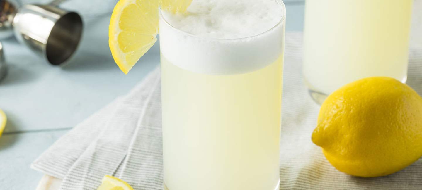 Cocktailglas med gin fizz på bord