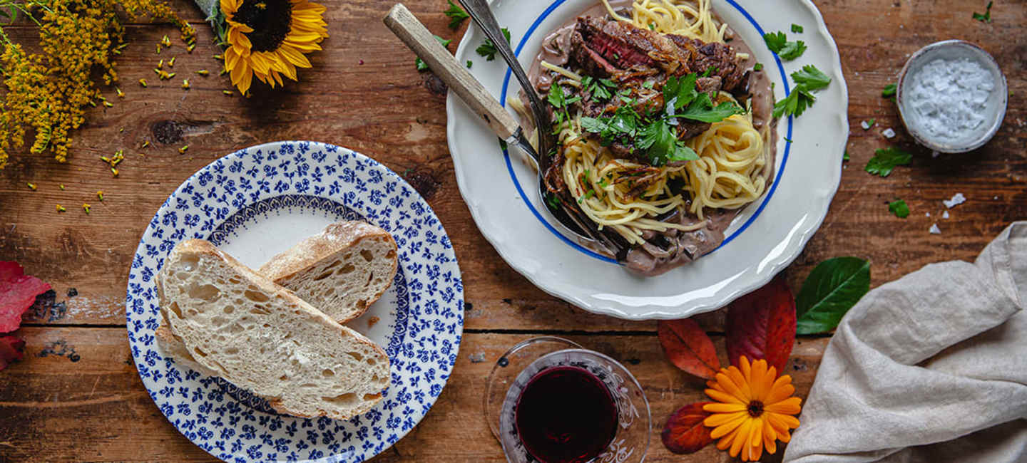 Krämig pasta med aubergine, entrecôte och karamelliserad lök med bröd