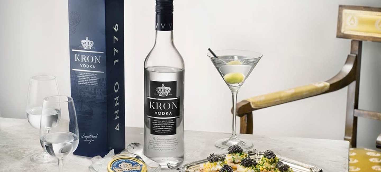 Kronvodka förpackning och flaska med ett martiniglas och fat med tilltugg