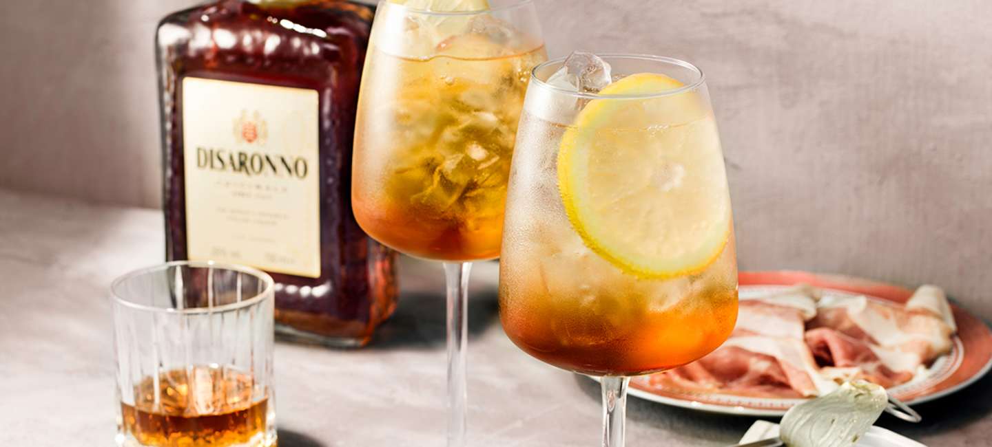 Disaronno Fizz med en flaska Disaronno i bakgrunden