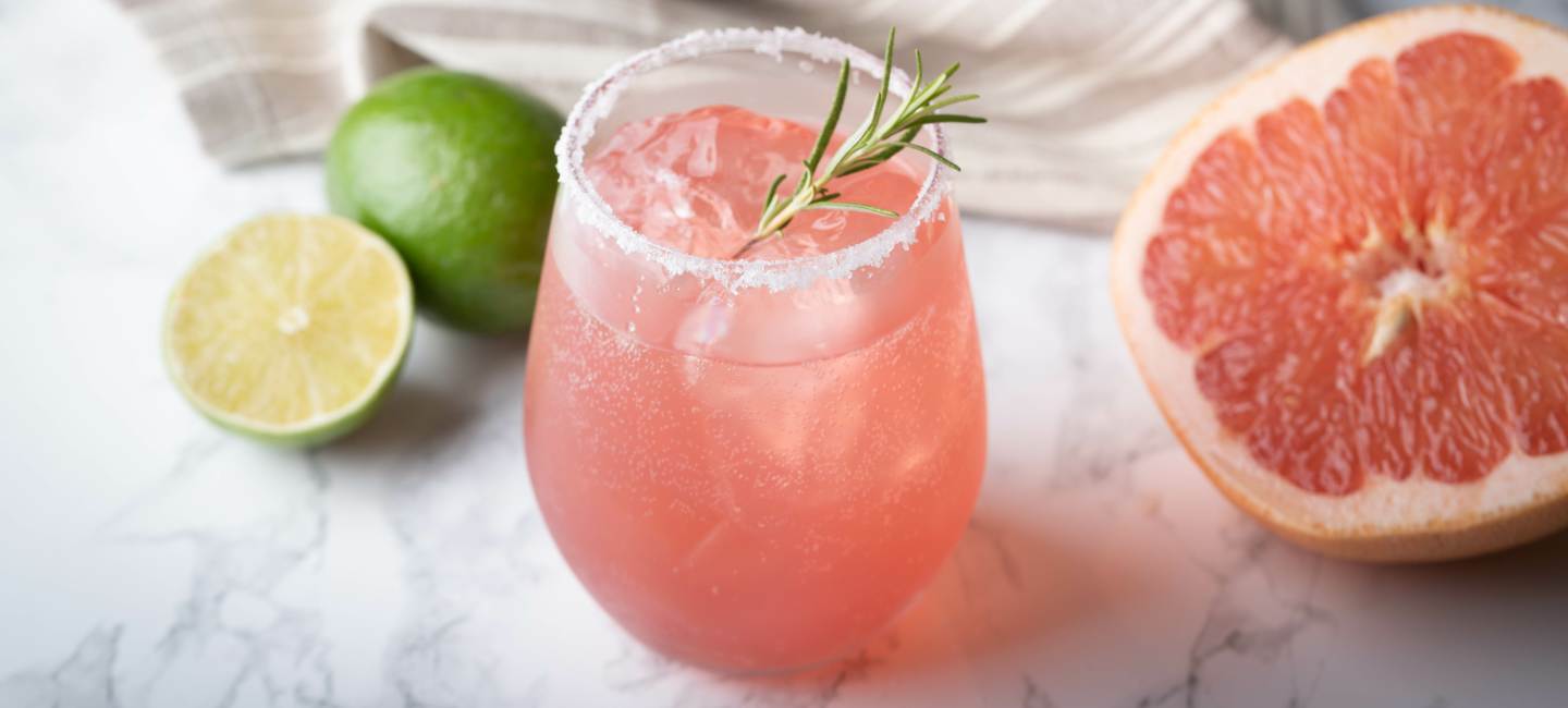 Paloma med en halv grapefrukt och lime på marmorbord