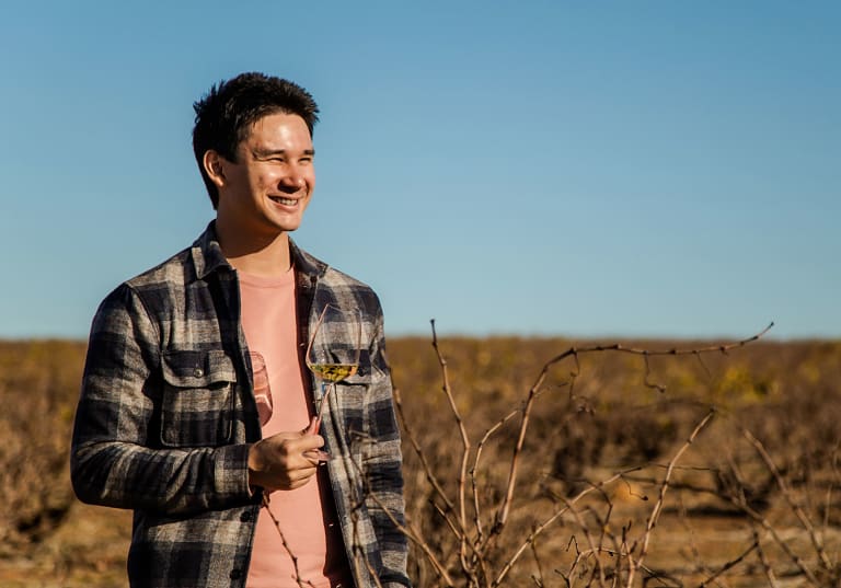 Matkreatören Filip Poon i Sydafrika med ett glas vitt vin på en vingård.