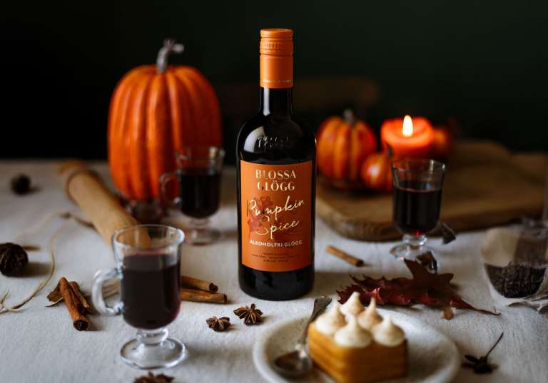 Blossa Pumpkin Spice på bord med pumpor och morotskaka.