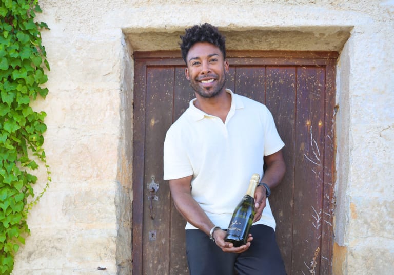 John Lundvik mot en brun dörr till ett stenhus i Bourgogne.