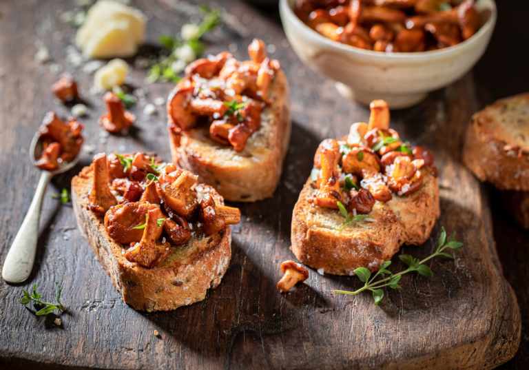 Tre stycken kantarelltoast på träbord.