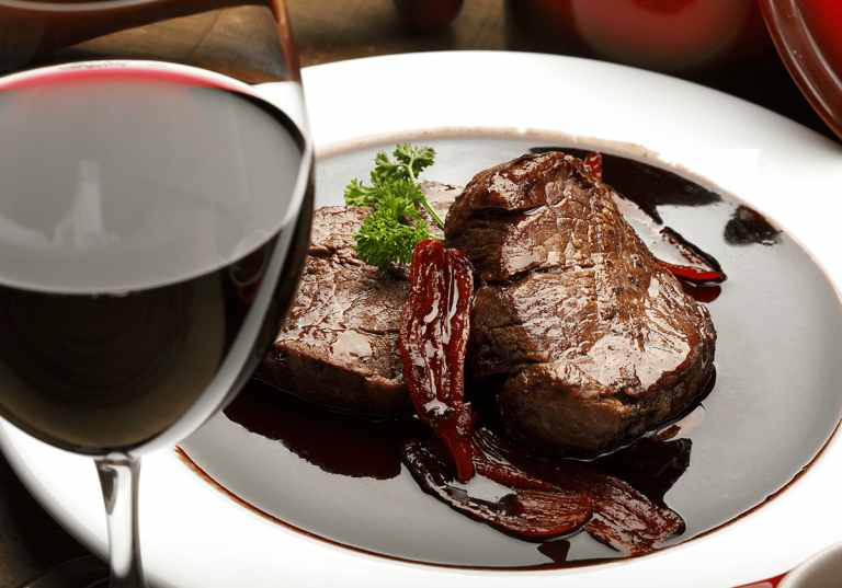 Vin i matlagning, här i rödvinssås och ett glas med rött vin.